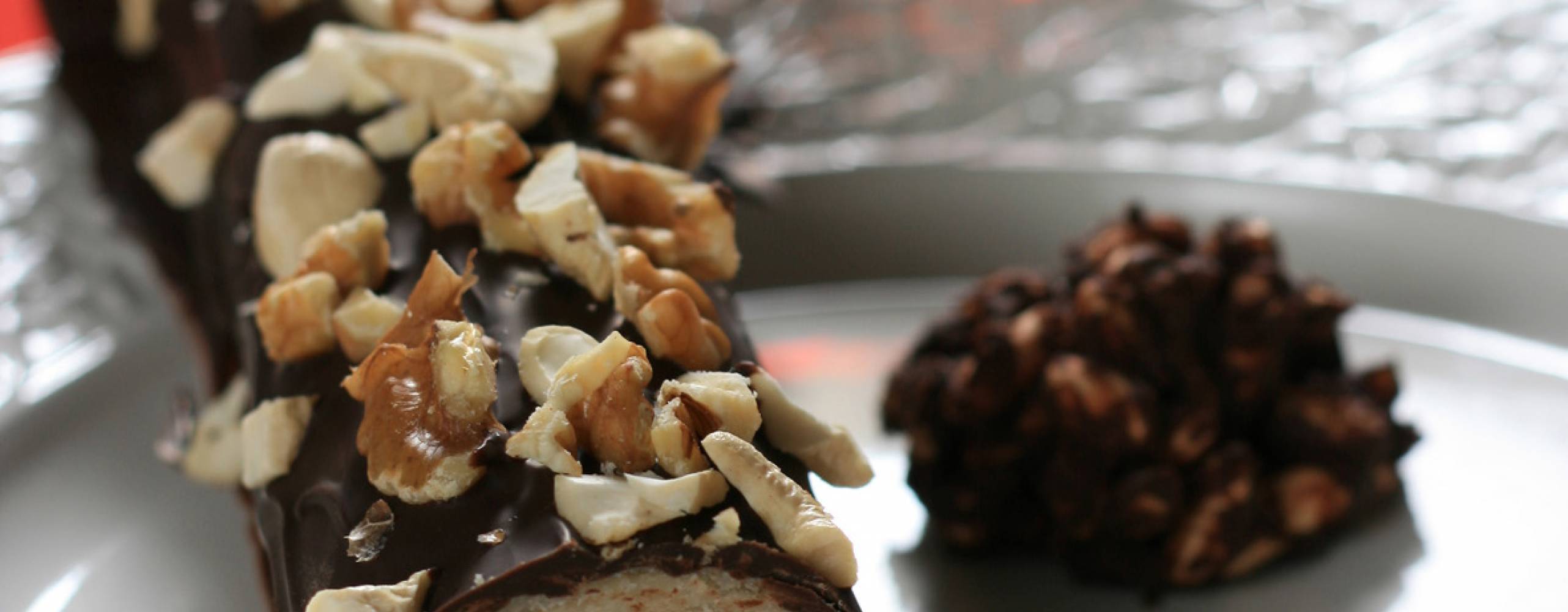 Marsipan- och nougatrulle Marsipan- och nougatrulle, dekorerad med cashewnötter och valnötter, på ett fat.
