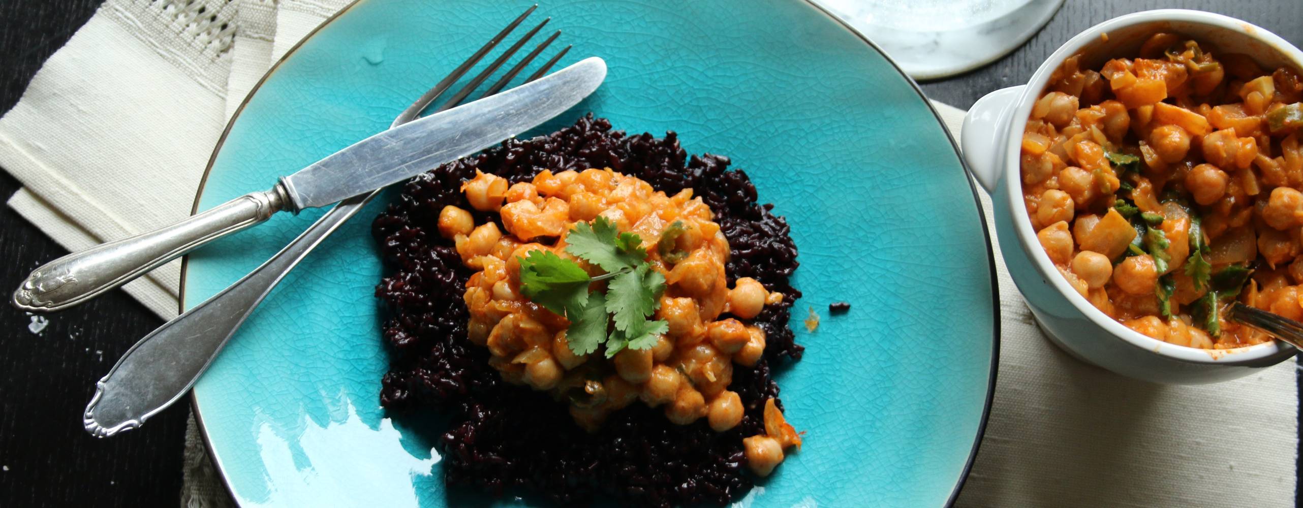 Kikärtscurry med svart ris på en turkos tallrik