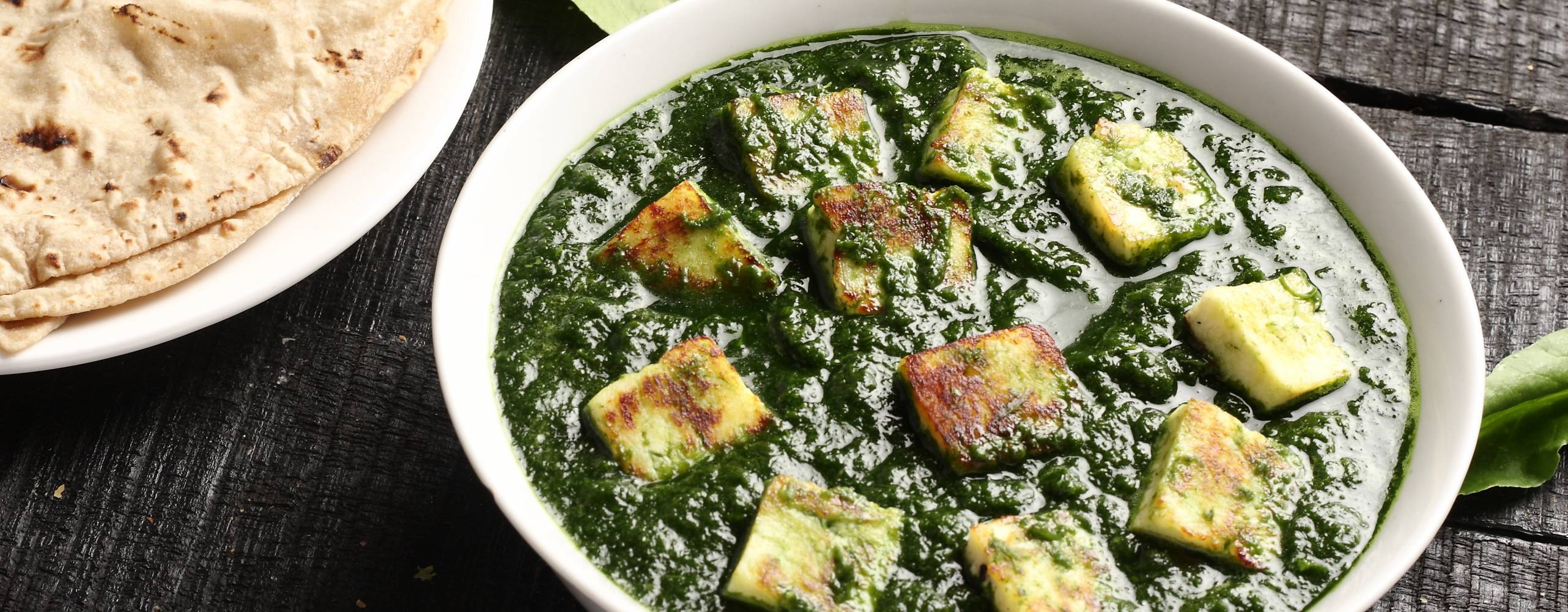 Foto: shutterstock - Sta Palak paneer och naan bröd på ett mörkt bord