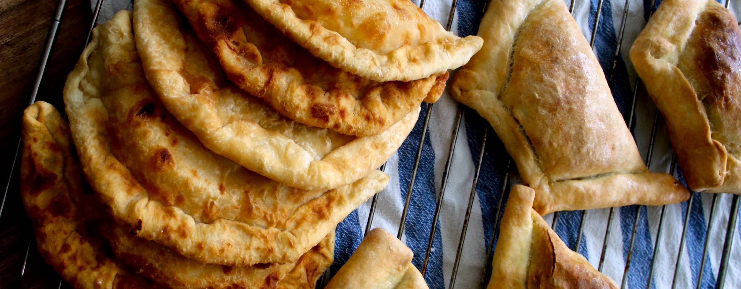 Tofufyllda piroger på en randig handduk bredvid en kavel.