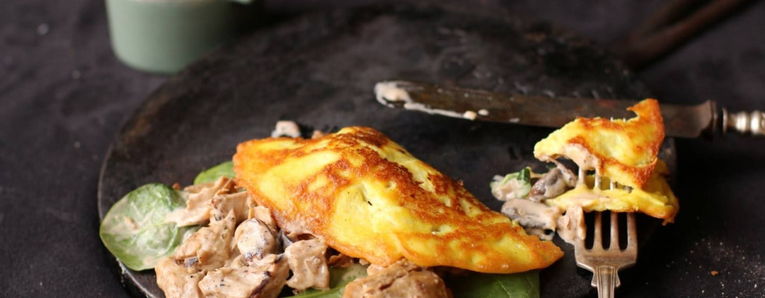 Vegansk omelette med Oumph Omelette med oumph på en svart tallrik på ett svart bord.