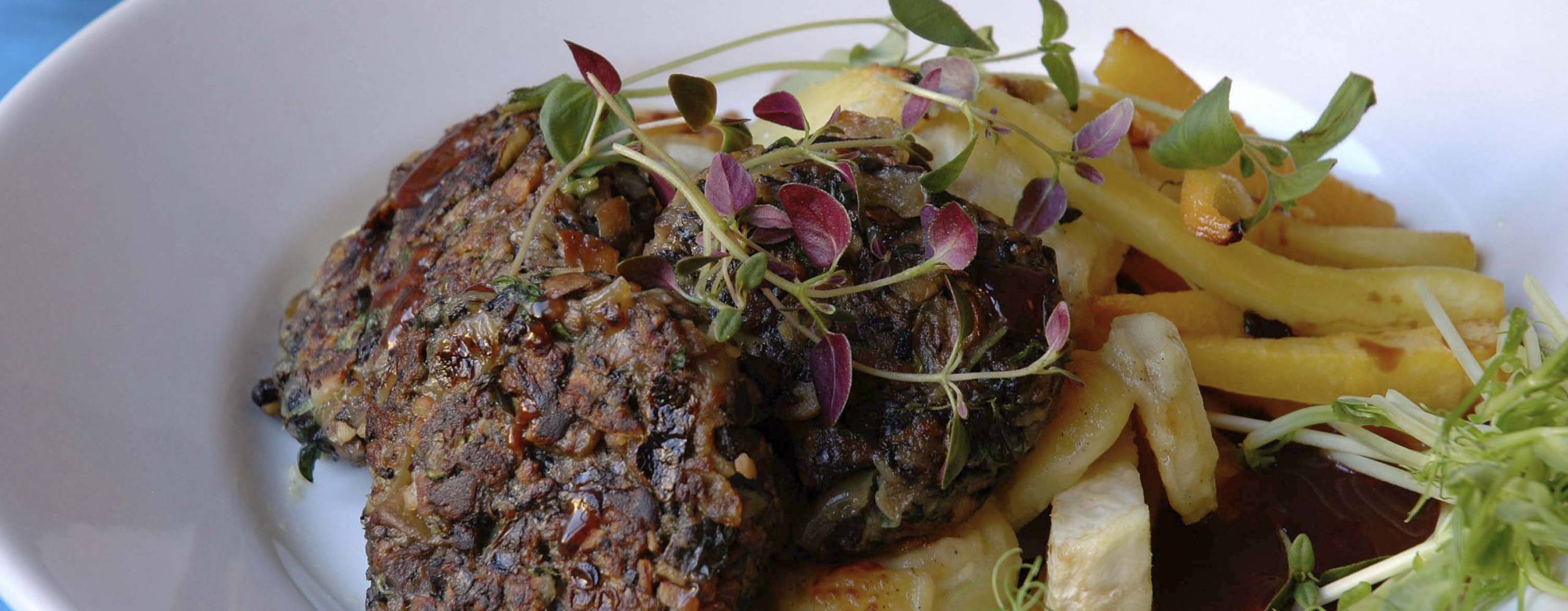 Svampbiffar Veganska svampbiffar med sås och potatis på en vit tallrik.