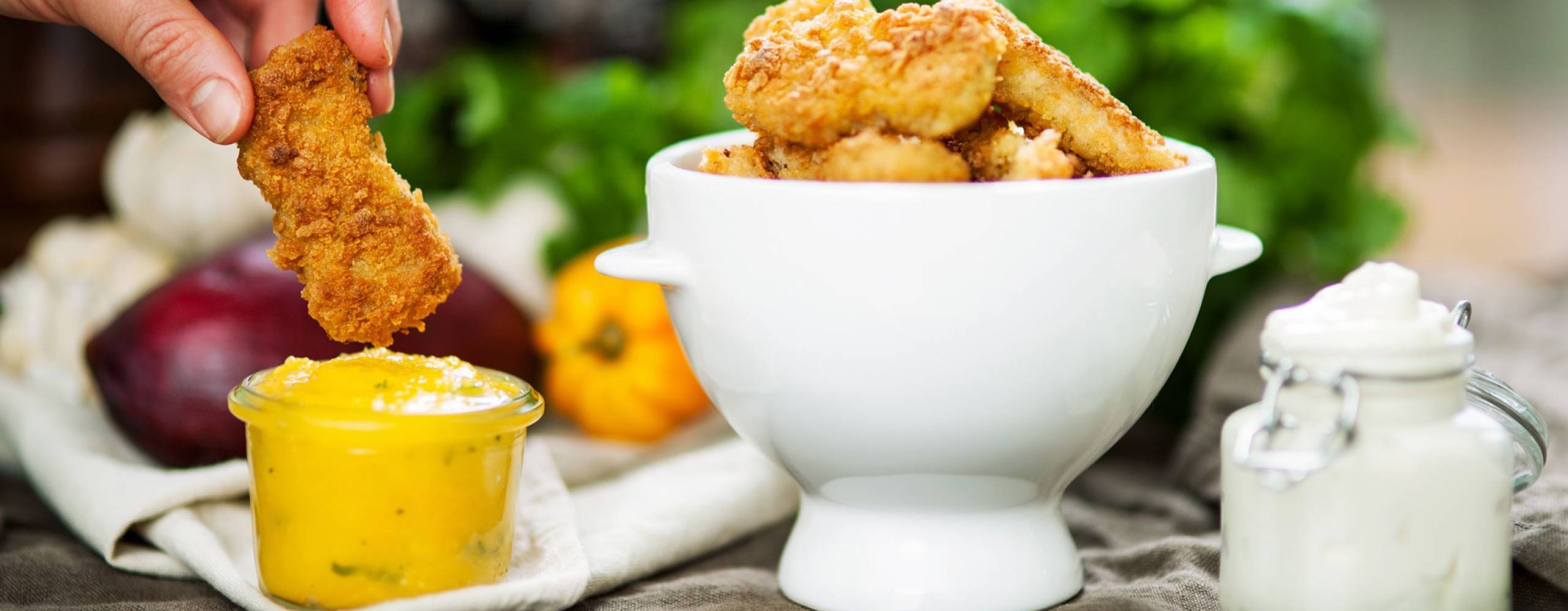 Nuggets med mango- och habanerosås eller aioli Nuggets i en vit skål, bredvid står en skål med mangosås.