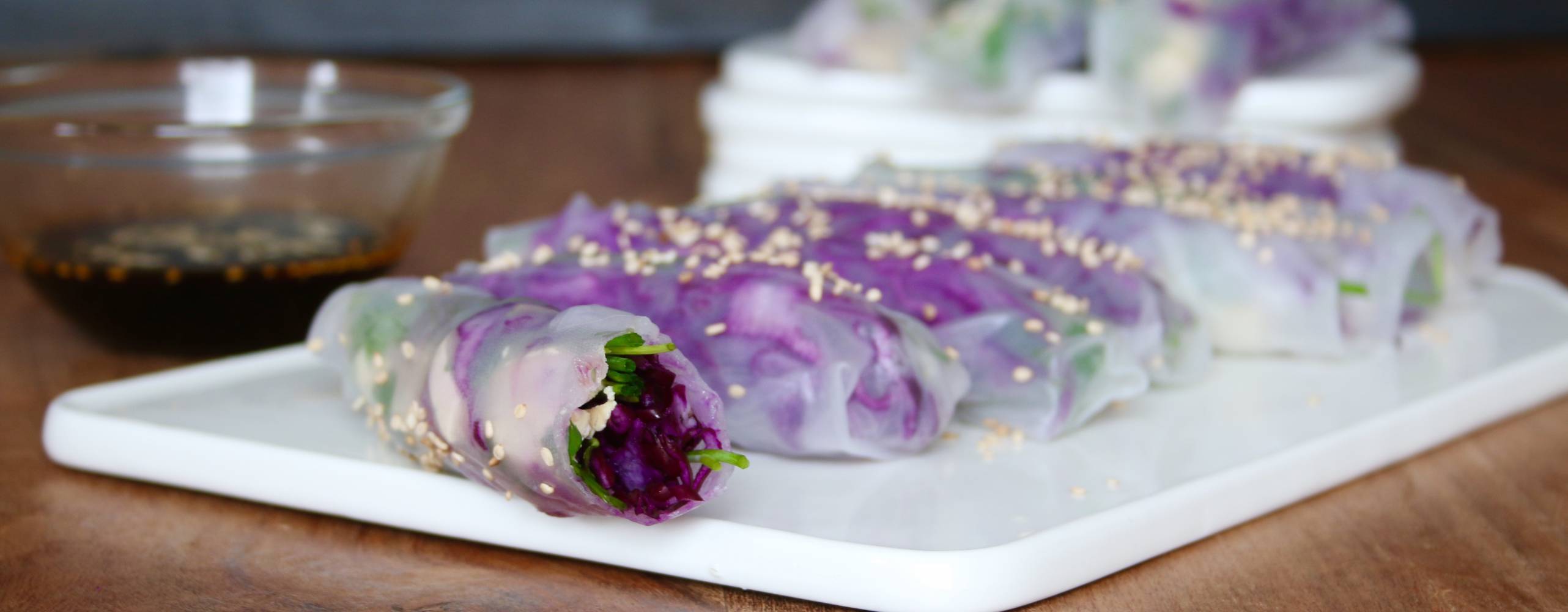 Rökiga risnudlar på en vit skärbräda. Bredvid står en skål med japansk soya.