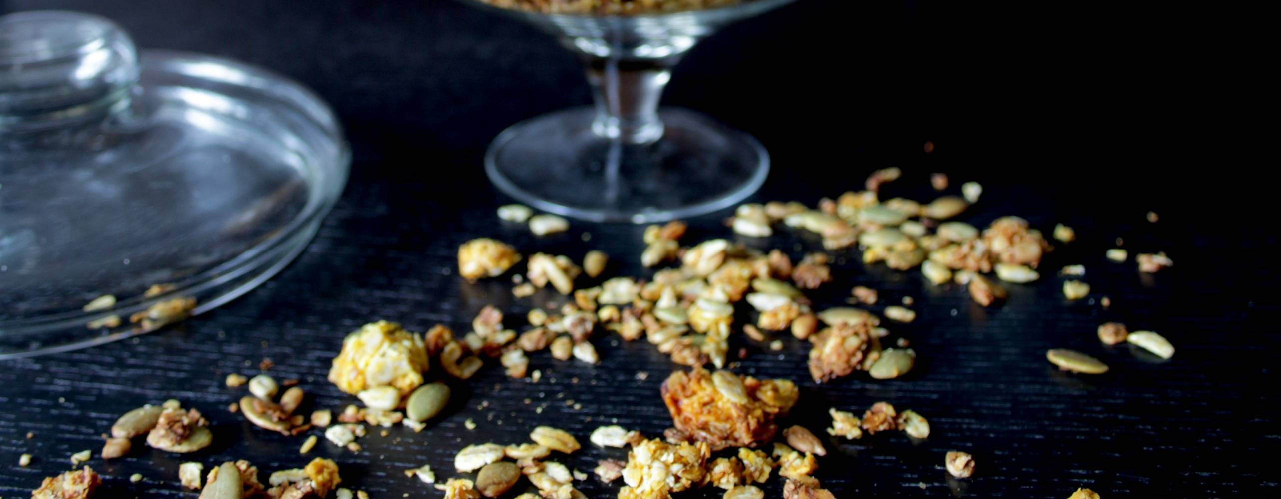 Julig saffransgranola Saffransgranola i en glasbägare på ett mörkt bord.