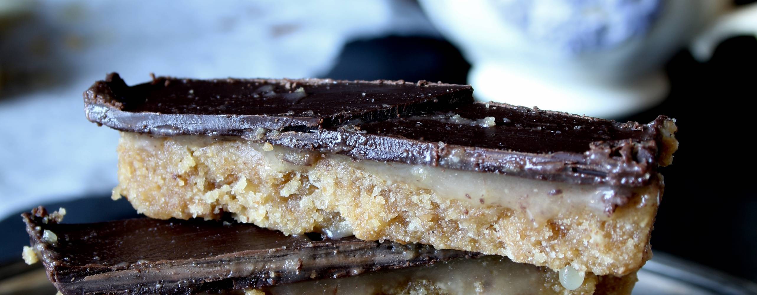 Twix-bitar på ett fat, i bakgrunden står en vit kaffekopp.