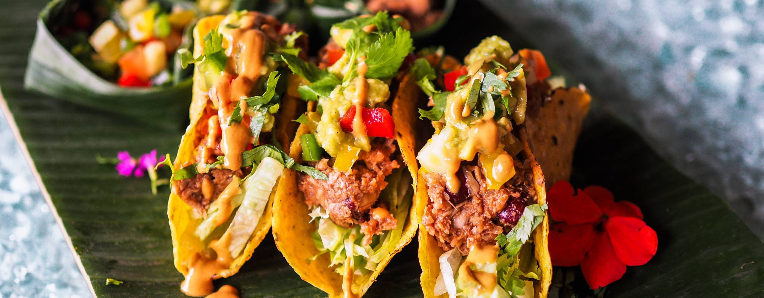 tre jackfruit tacos på en svart bräda