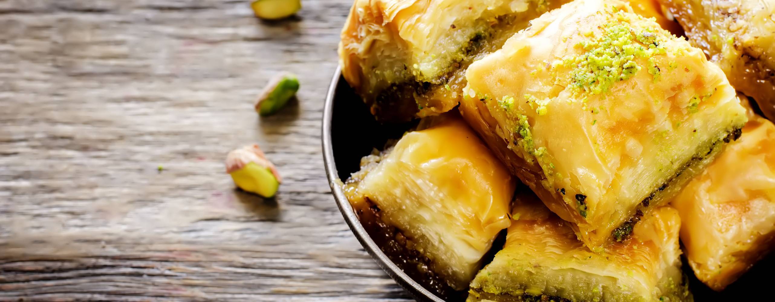 Et fat med baklava på ett träbord.