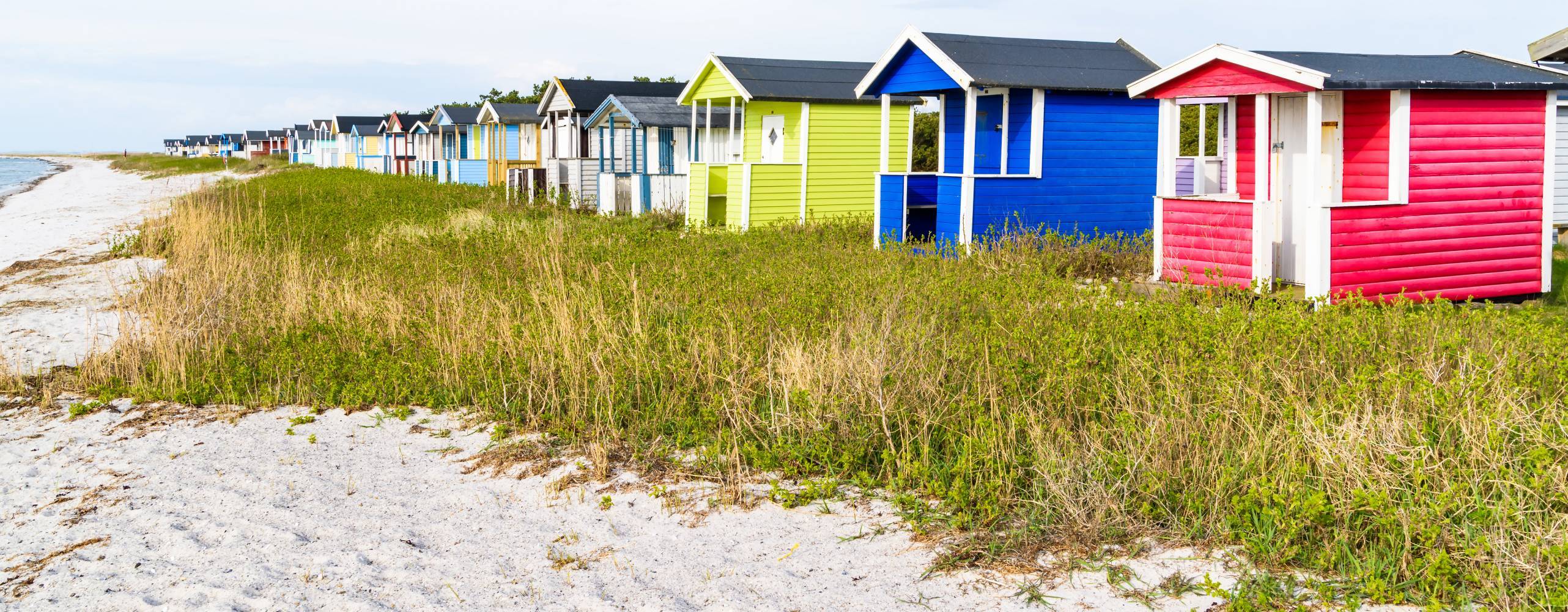 Bild på små färgglada hus i Skånevid stranden