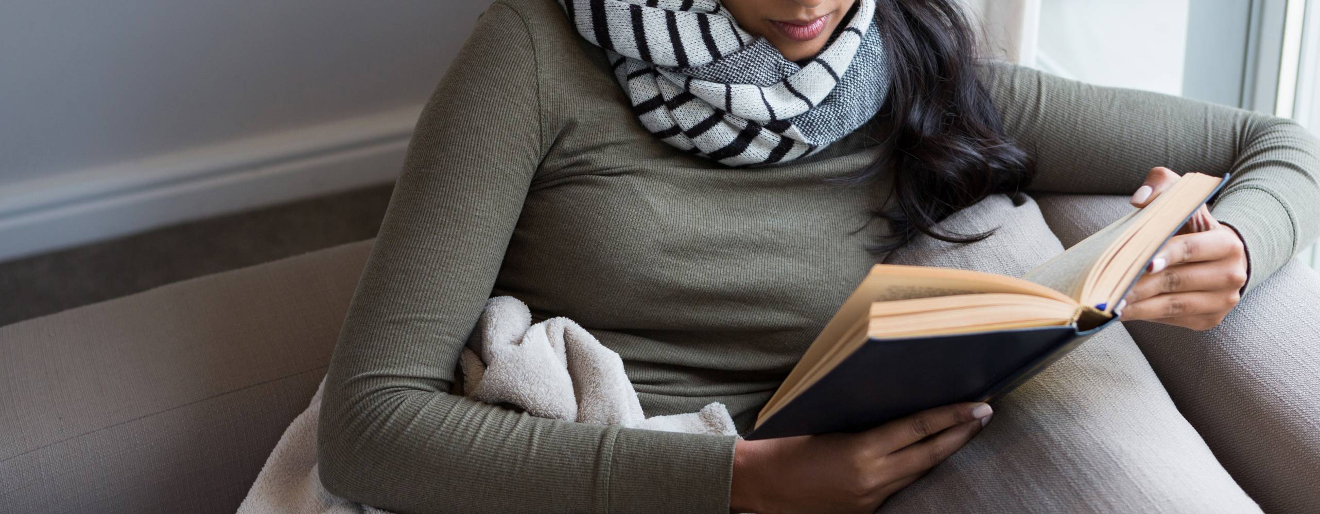 person sitter i soffa och läser