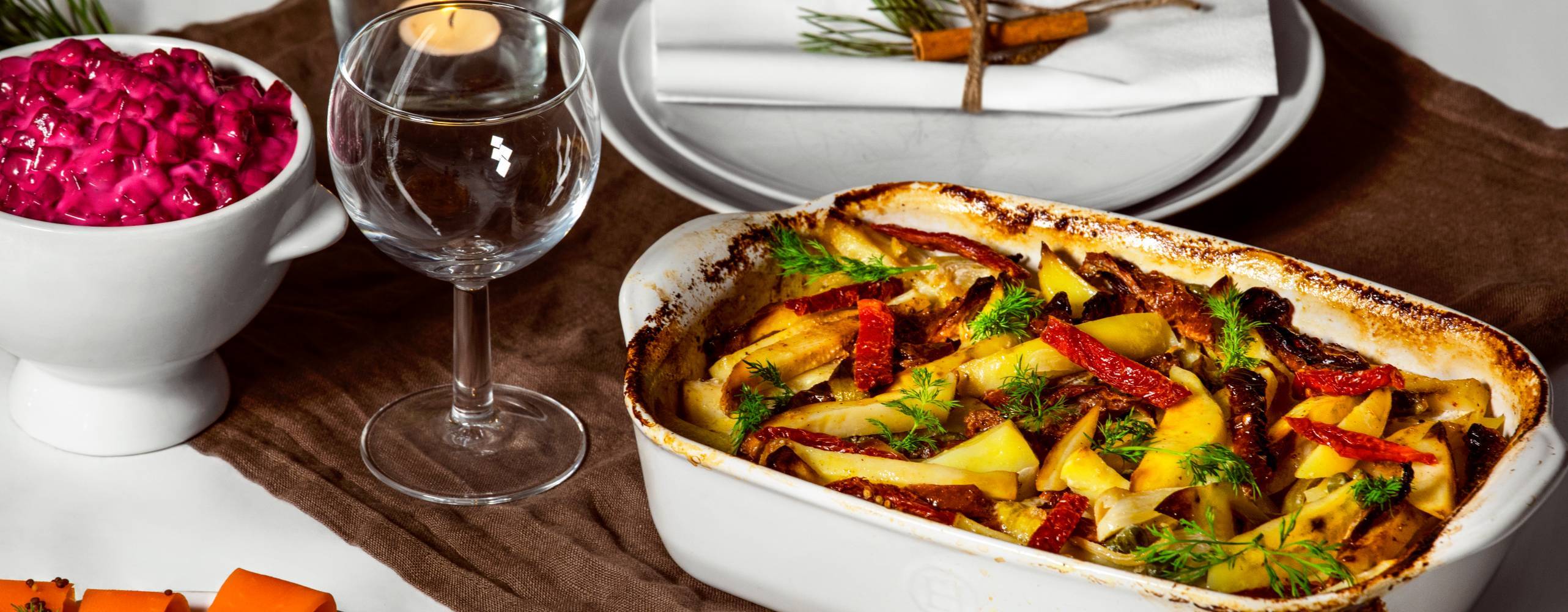 Janssons frestelse i en vit ugnsform på ett dukat bord.