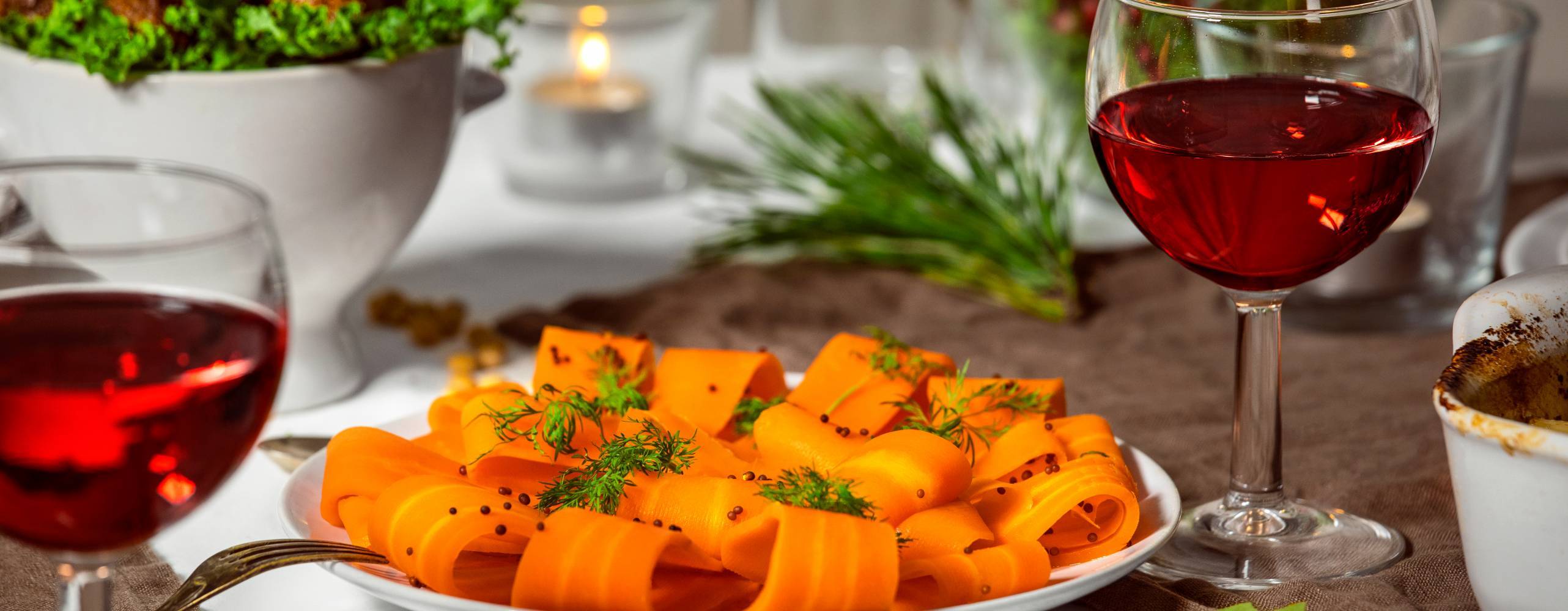 Gravad morot på en vit tallrik på ett dukat bord