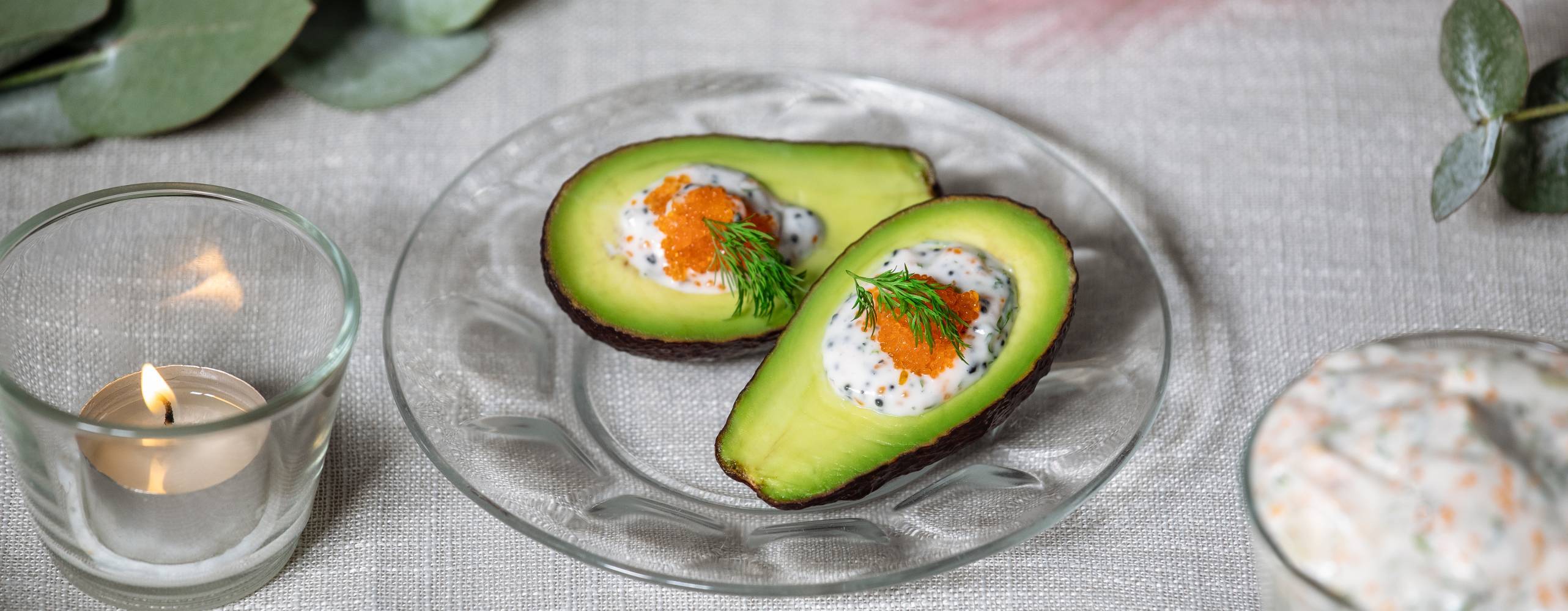 Skagenfyllda avokadohalvor på ett glasfat.