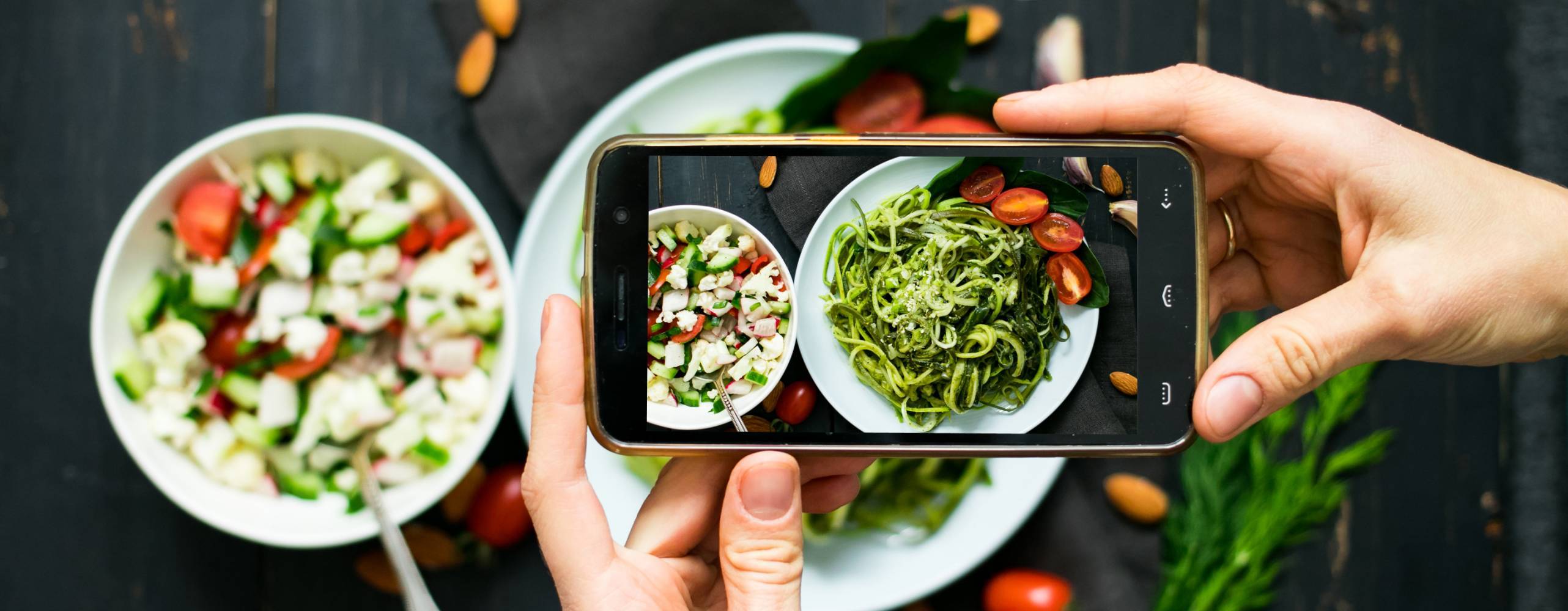 Person tar bild på sin tallrik med mat med sin mobiltelefon