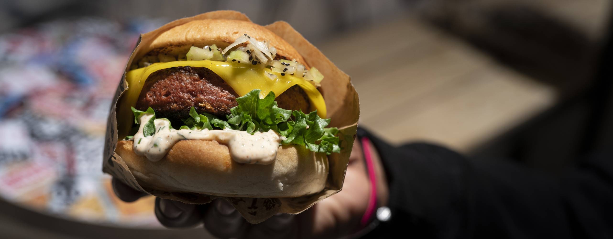 Person håller upp en vegansk burgare