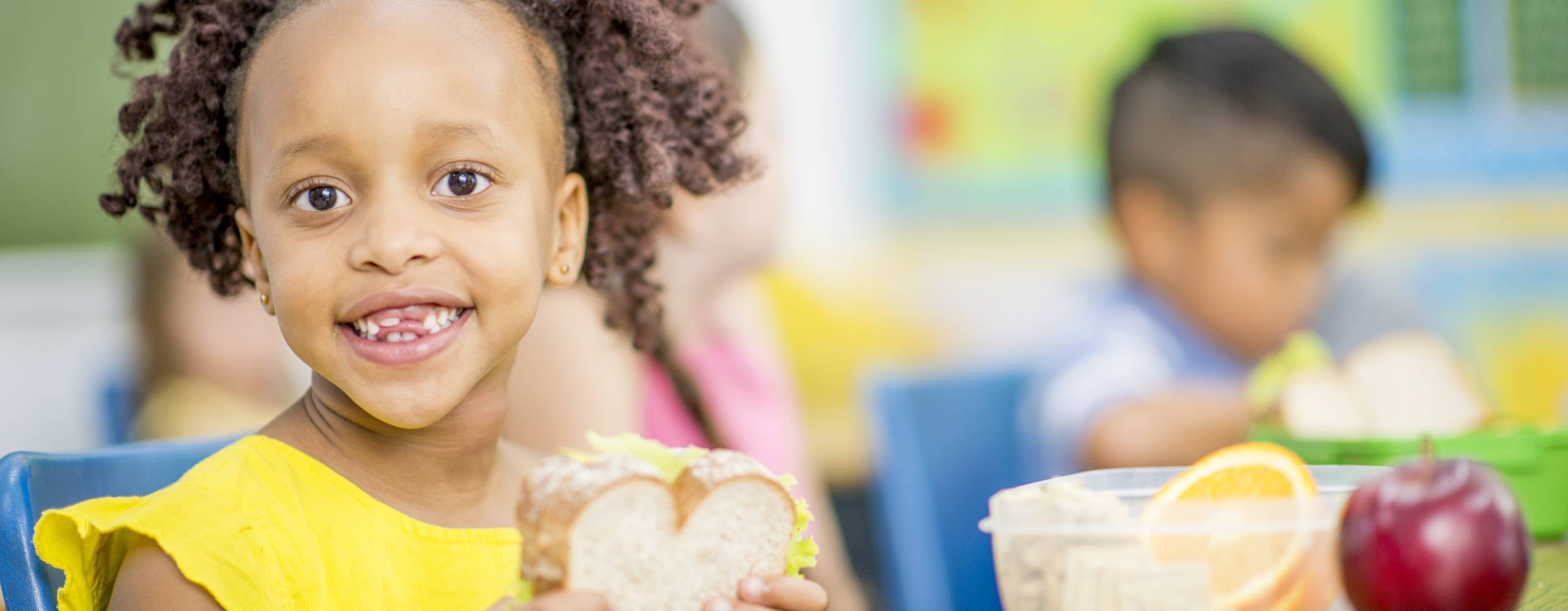 Barn sitter och äter macka