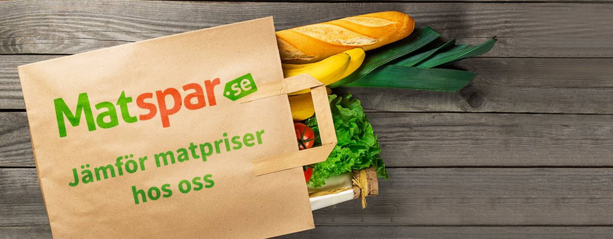 Liggande papperskasse där en baguette och grönsaker sticker ut