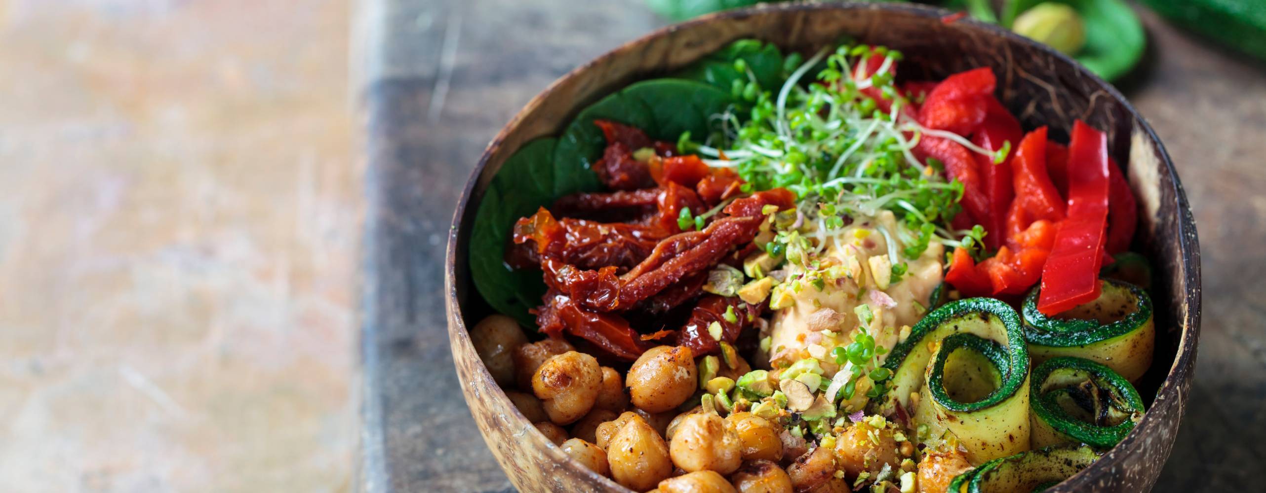 En vegansk bowl med hummus, paprika, kikärtor, krasse bland andra grönsaker.