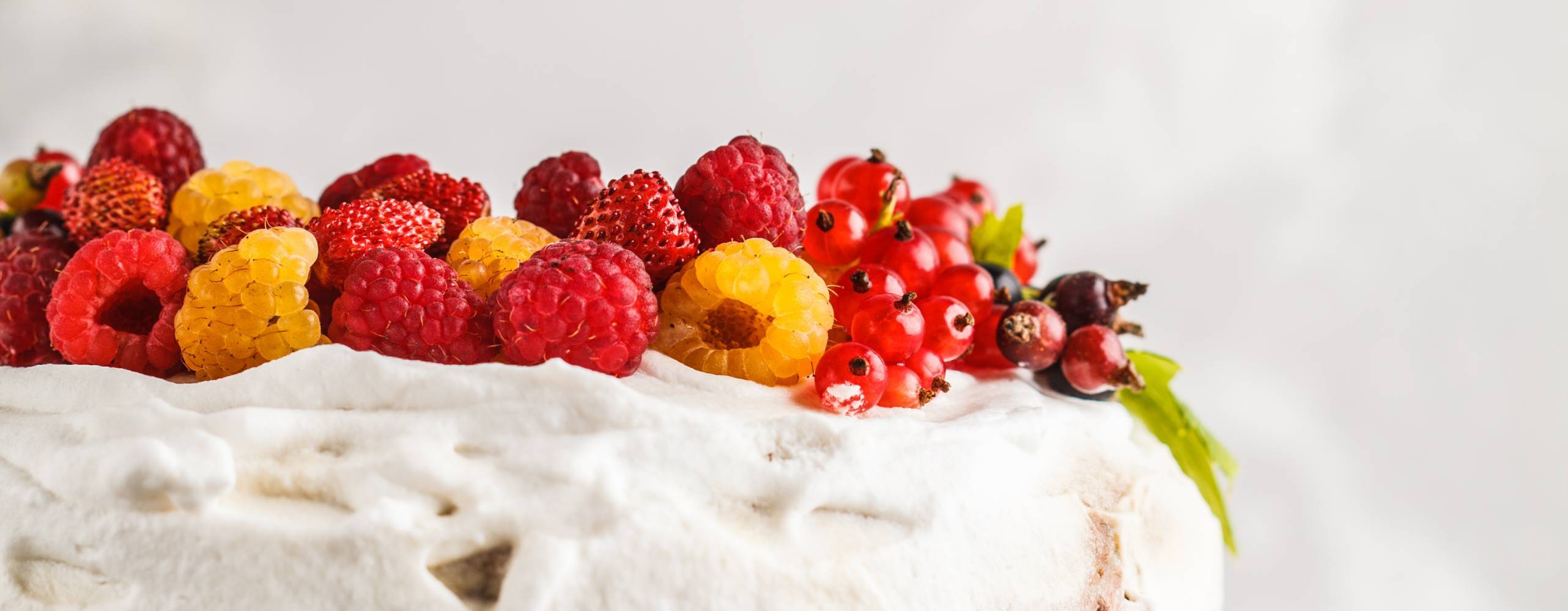 Vegansk somrig tårta toppad med hallon och röda vinbär