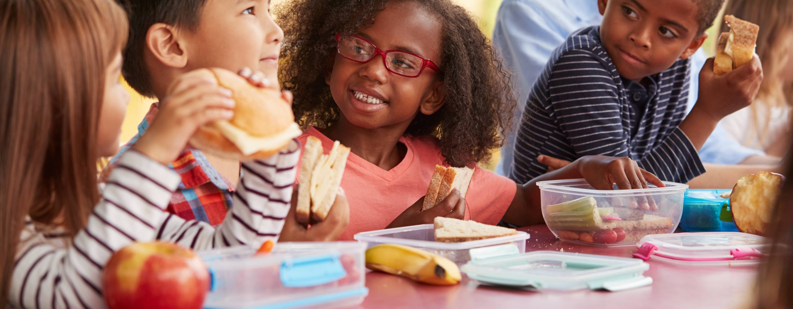 Fem barn sitter runt ett bord