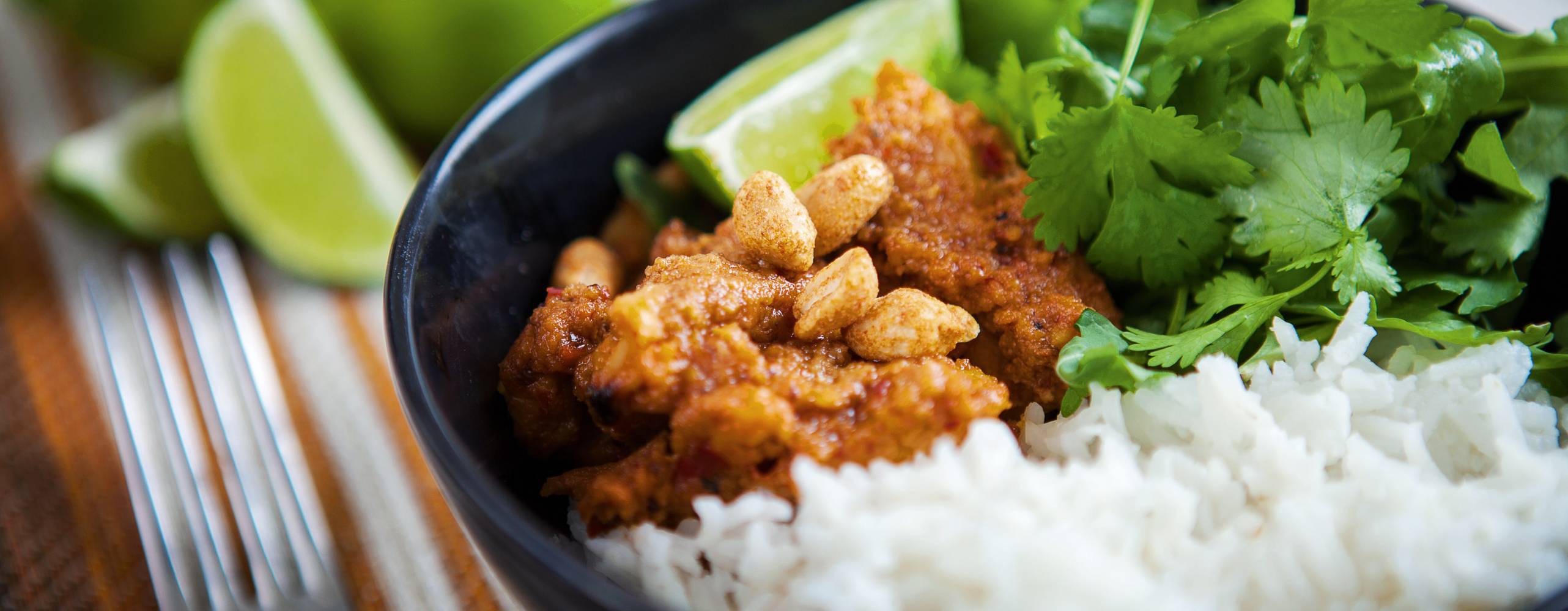 Skål med ris, vegobitar i jordnötssås och koriandersallad