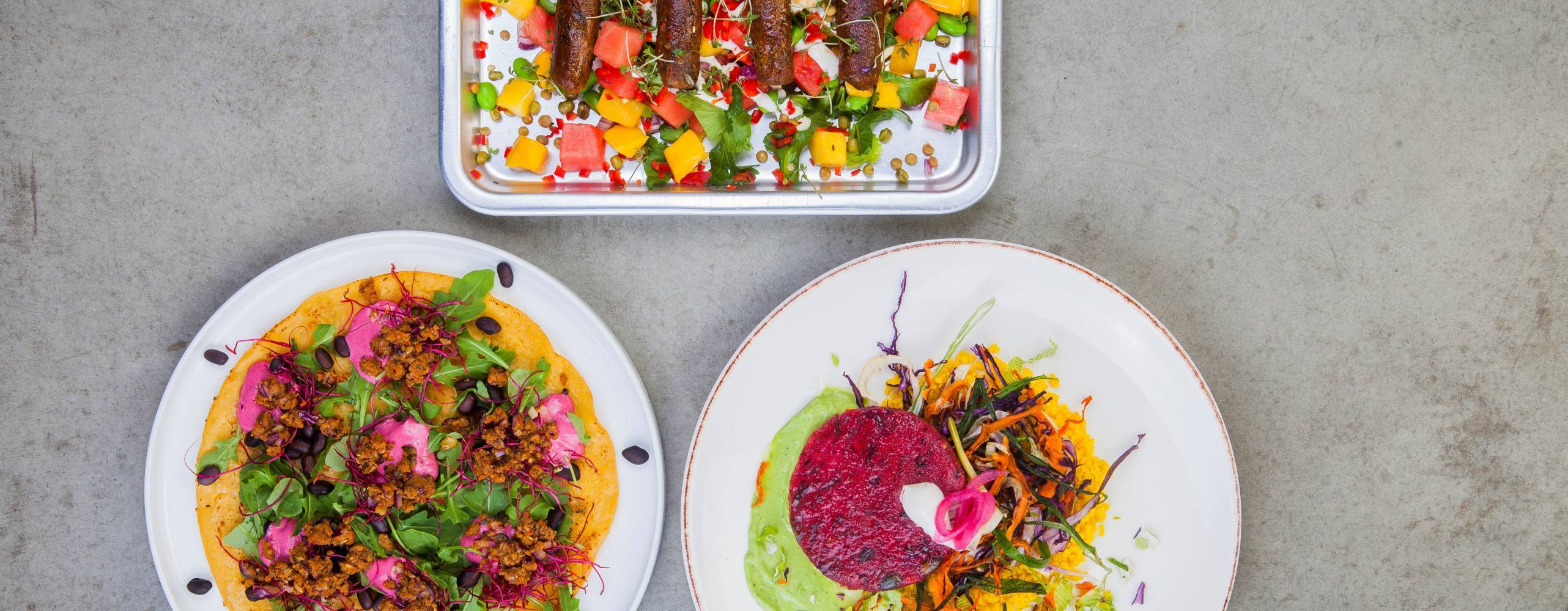 Tre veganska rätter med diverse innehåll på ett bord