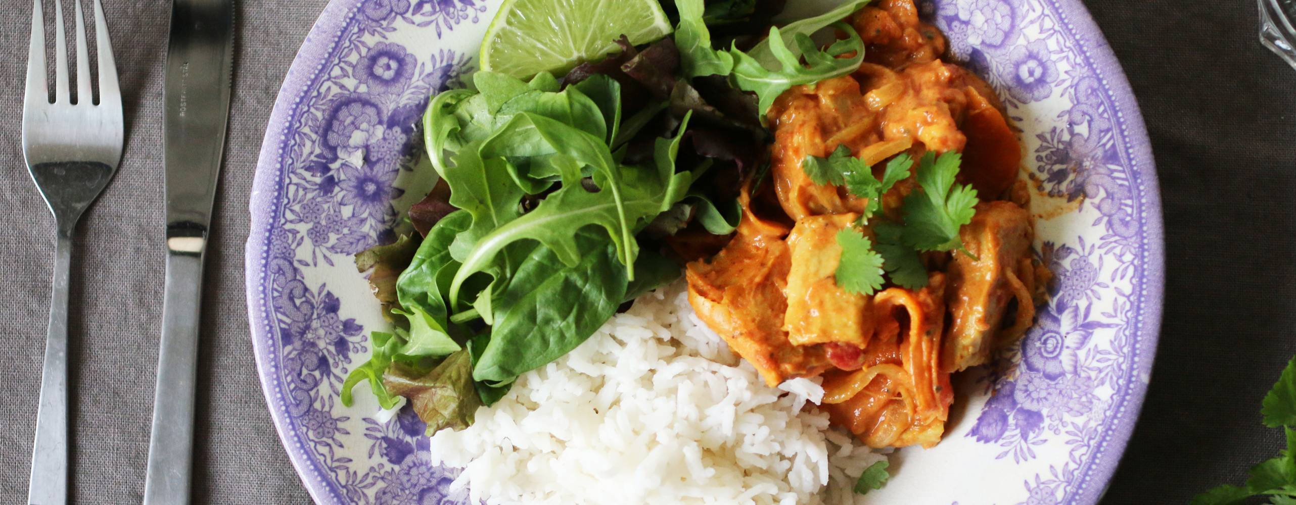 Tallrik med vegansk tikka masala, ris och grönsaker