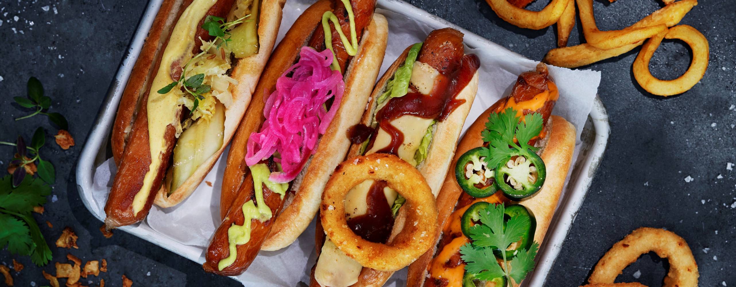 Flera veganska korvar med bröd på en bricka