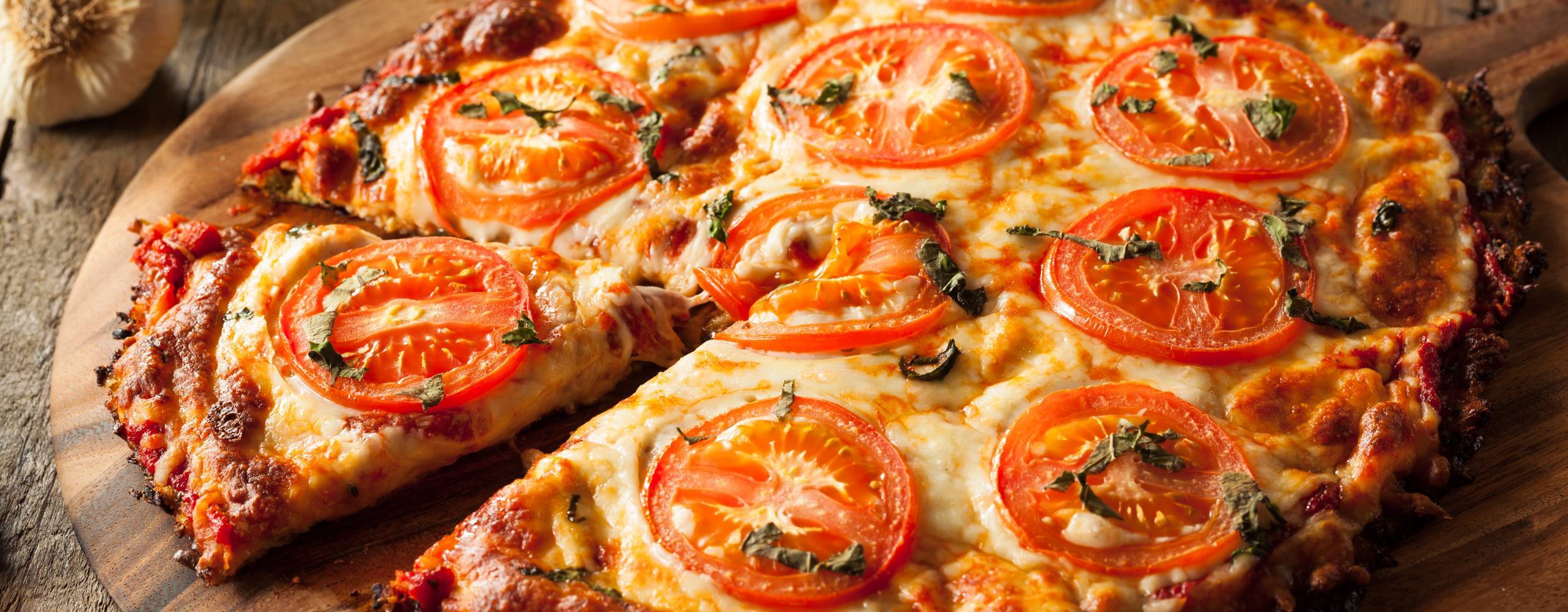 Vegansk pizza på rund träbräda