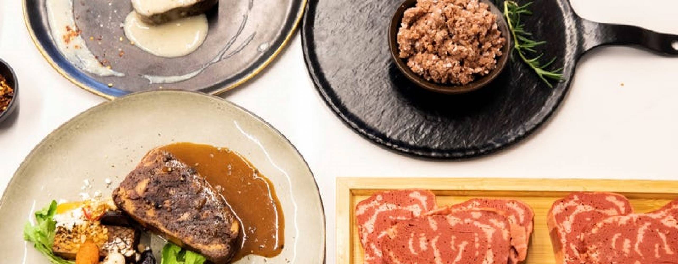 vegansk 3D kött i två olika tallrikar och en stekpanna