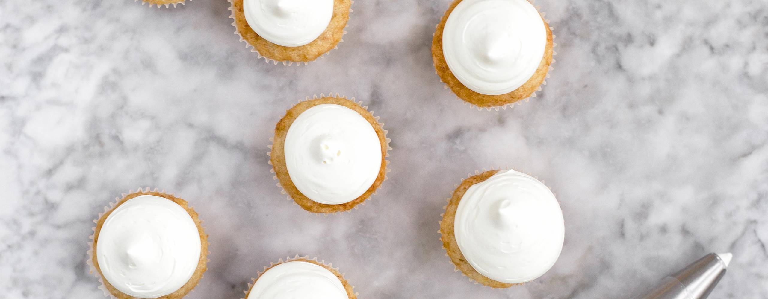 Foto: Karolina Tegelaar, Vegansk bakning Bananmuffins med aquafaba har här gräddats i minimuffinsformar i 175°C i 13-15 minuter. Godisfluff av smälta bananskumgodisar är spritsat med en rund spritstyll på en centimeter.