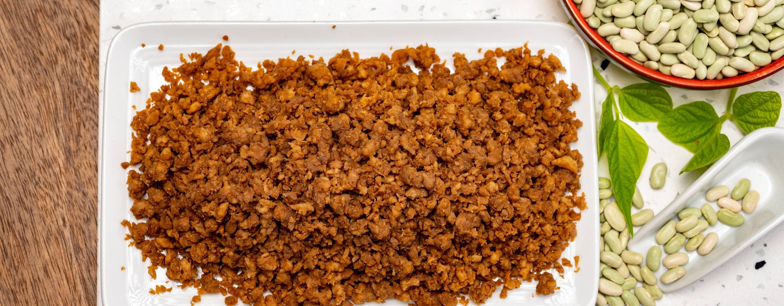 vegansk färs på en tallrik intill okokta bönor