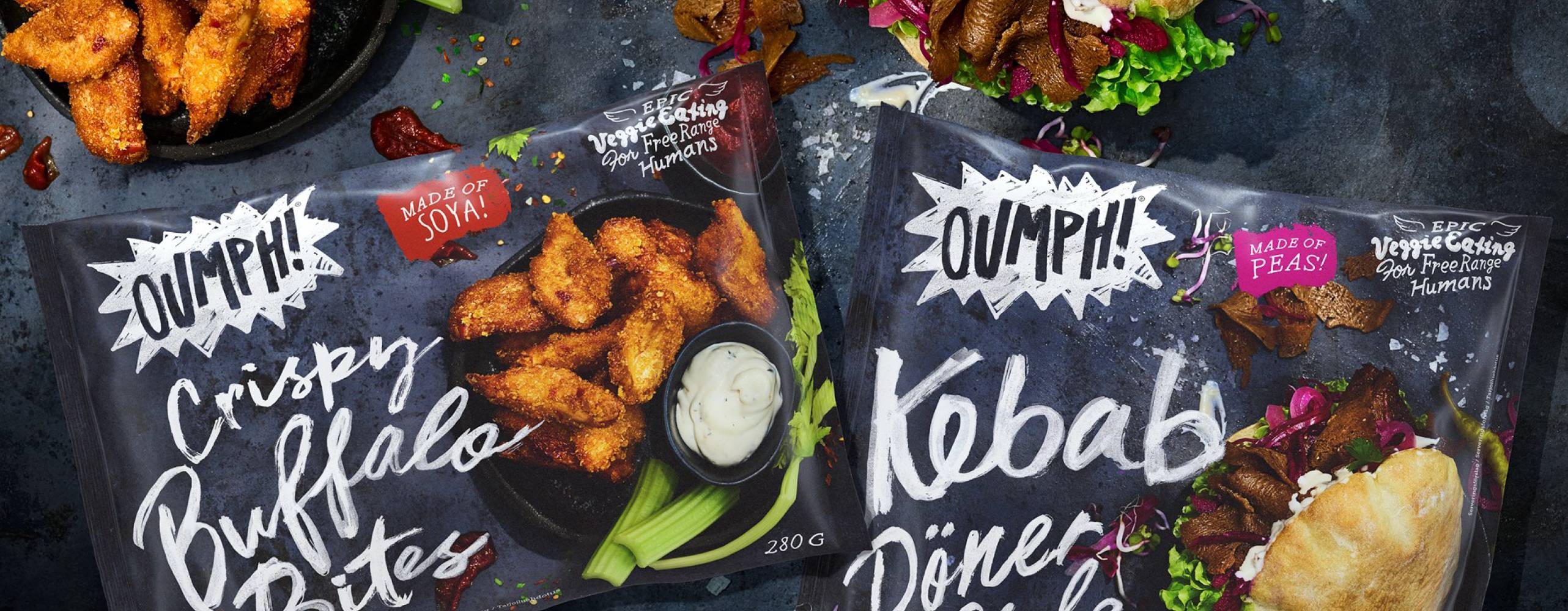 Foto: Oumph! Två förpackningar med Oumph! Crispy Buffalo Bites samt Oumph! Kebab Döner Style. Vid sidan av finns produkterna upplaga för servering.