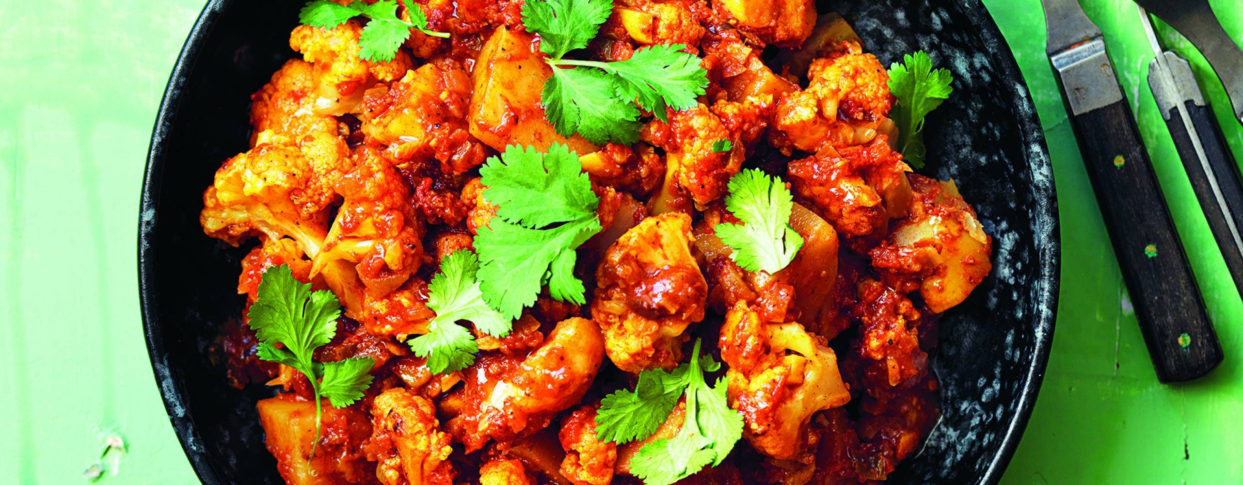 Foto: Green India Aloo gobi i djup tallrik på bord.