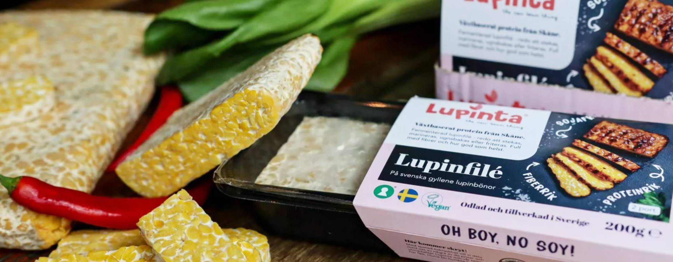 Lupinfilé från Lupinta, både i- och utanför förpackning, på bänk med grönsaker.