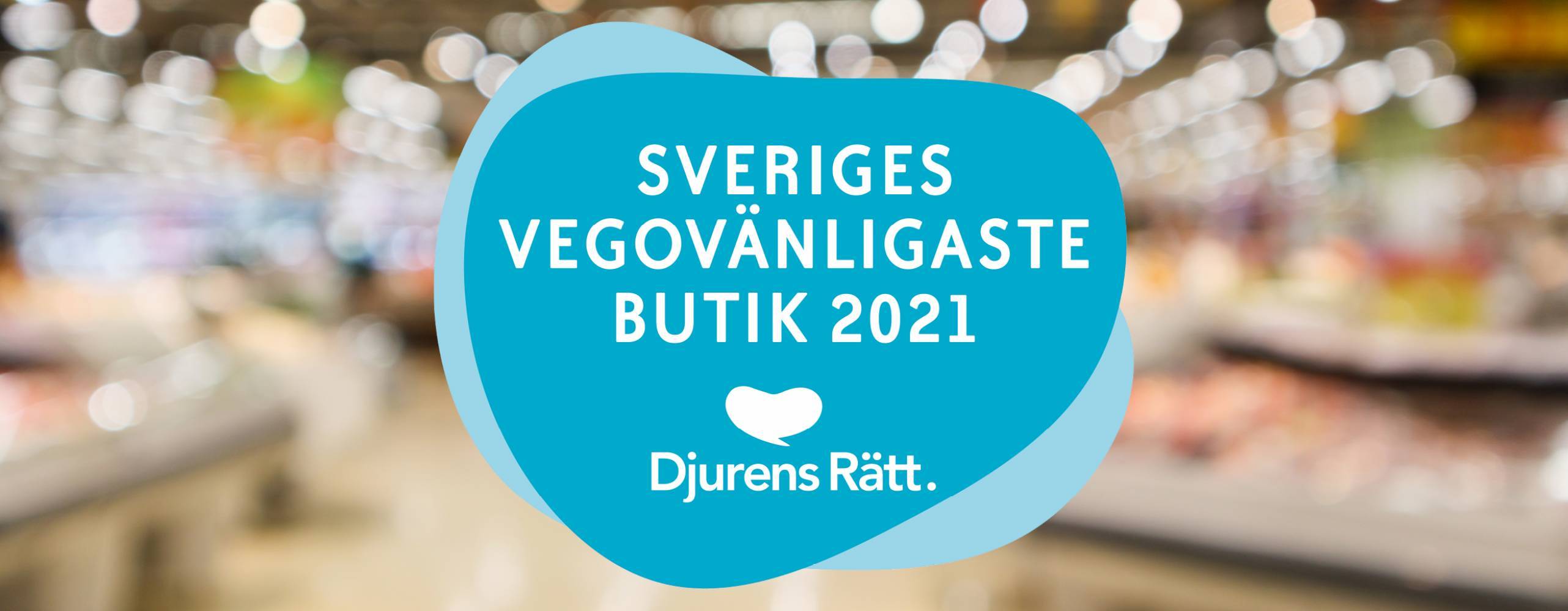 Blå dekal för Sveriges vegovänligaste butik, mot oskarp miljöbild från butik.