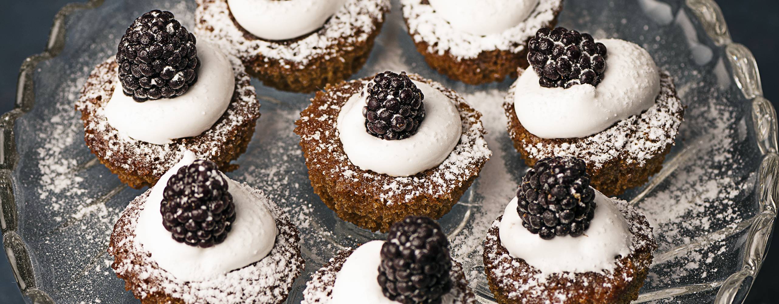 Minijulmuffins garnerade med grädde, björnbär och florsocker.