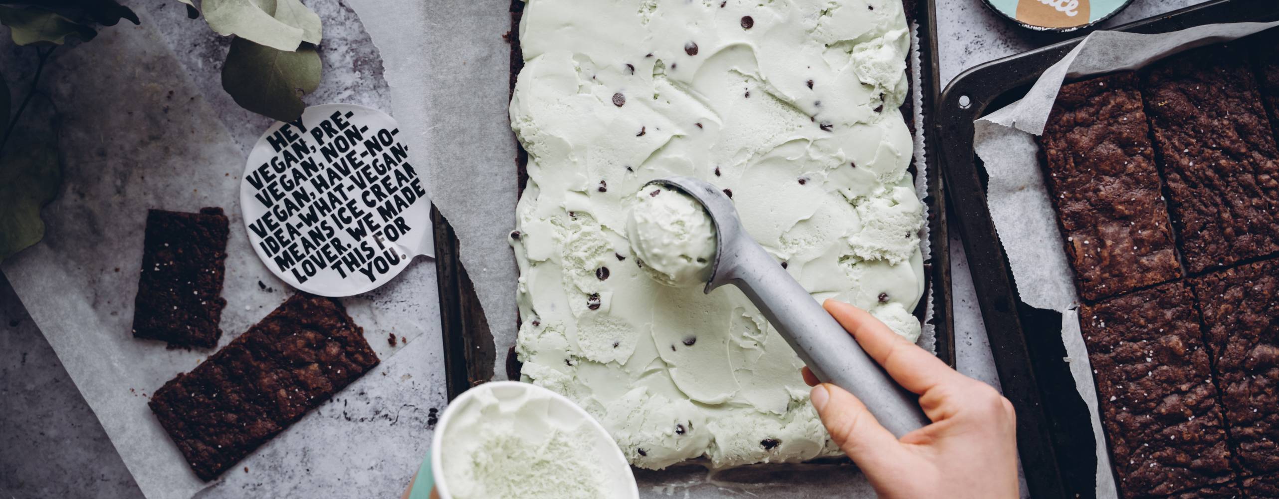 Produktfoto: Oatly Vegansk mintchoklad glass skopas och läggs på en brownie i en långpanna.
