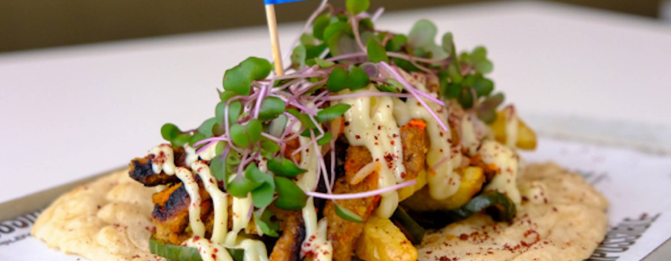 En tortilla med veganska nuggets och grönsaker på serverad på en bricka.