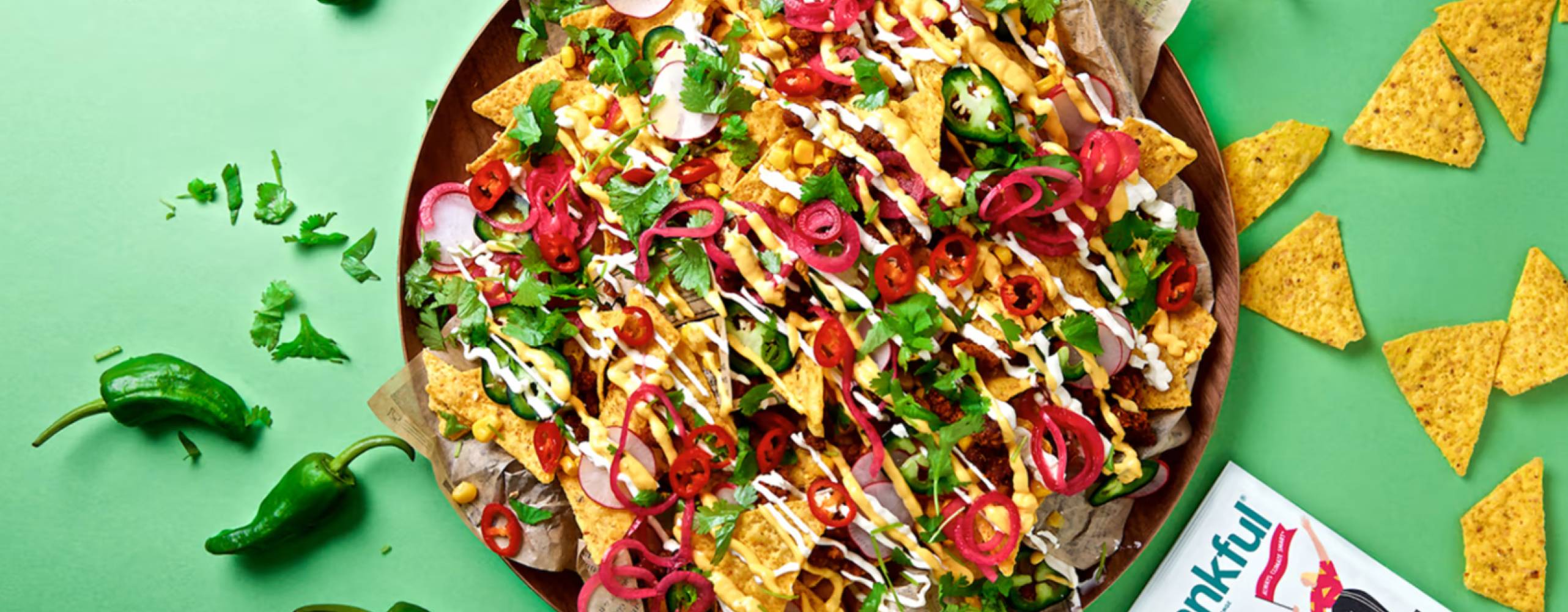 Nachotallrik med Frankfuls produkter mot en grön bakgrund