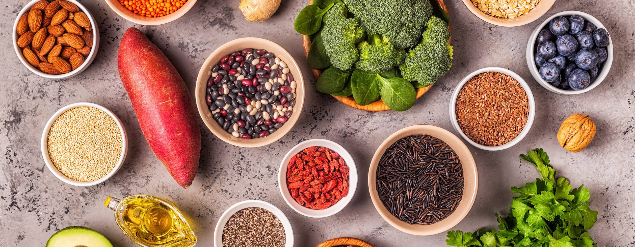 Växtbaserade råvaror uppdukade i skålar på ett grått bord.