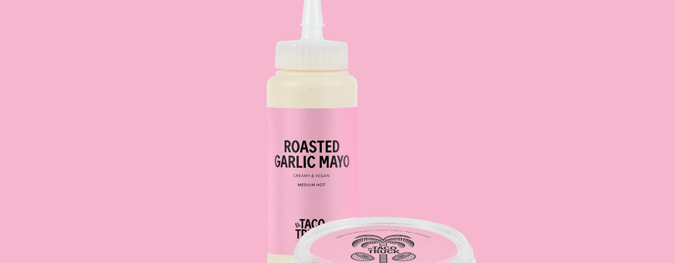 Vegansk ostsås i en flaska och guacamole på ärta i en burk mot en rosa bakgrund.