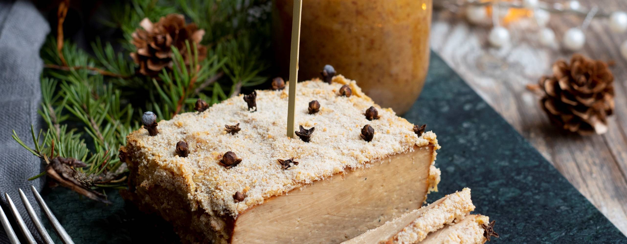 Griljerad tofu på en mörk marmorplatta på ett uppdukat julbord.
