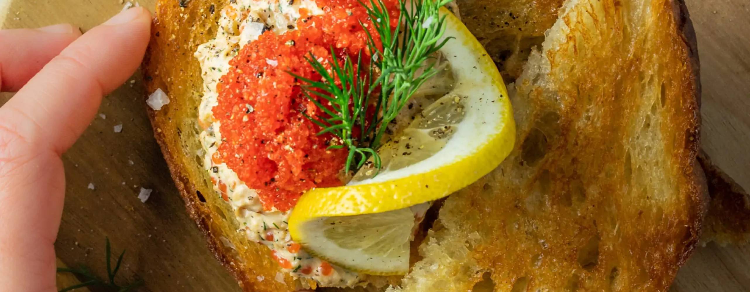 Vegansk skagen upplagt på stekt bröd toppad med tångrom, dill och citron
