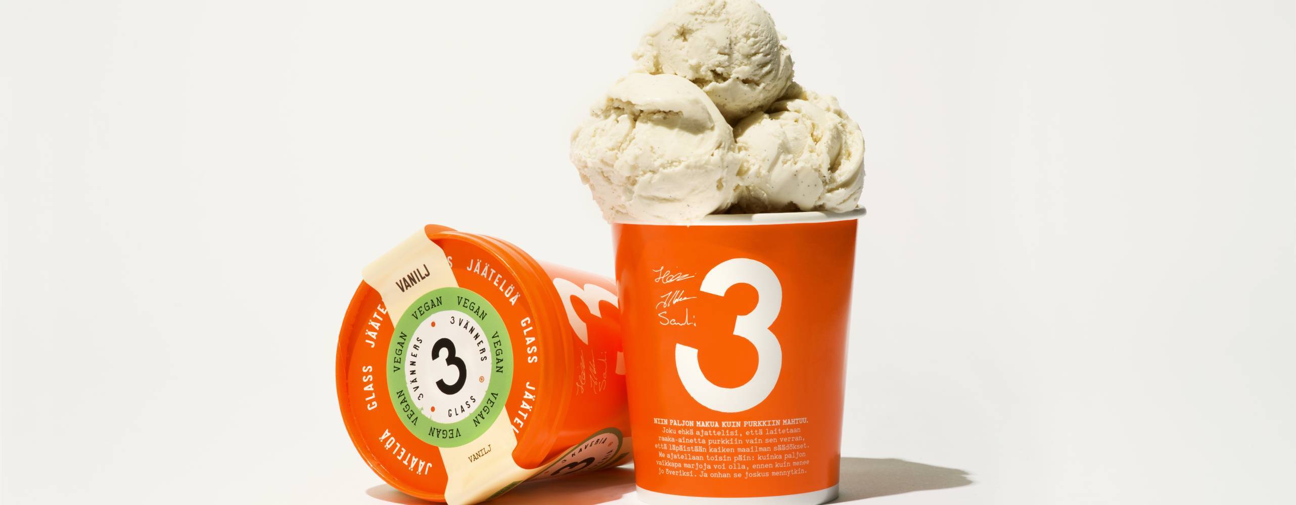 Vegansk vaniljglass i orange pappburk mot vit bakgrund