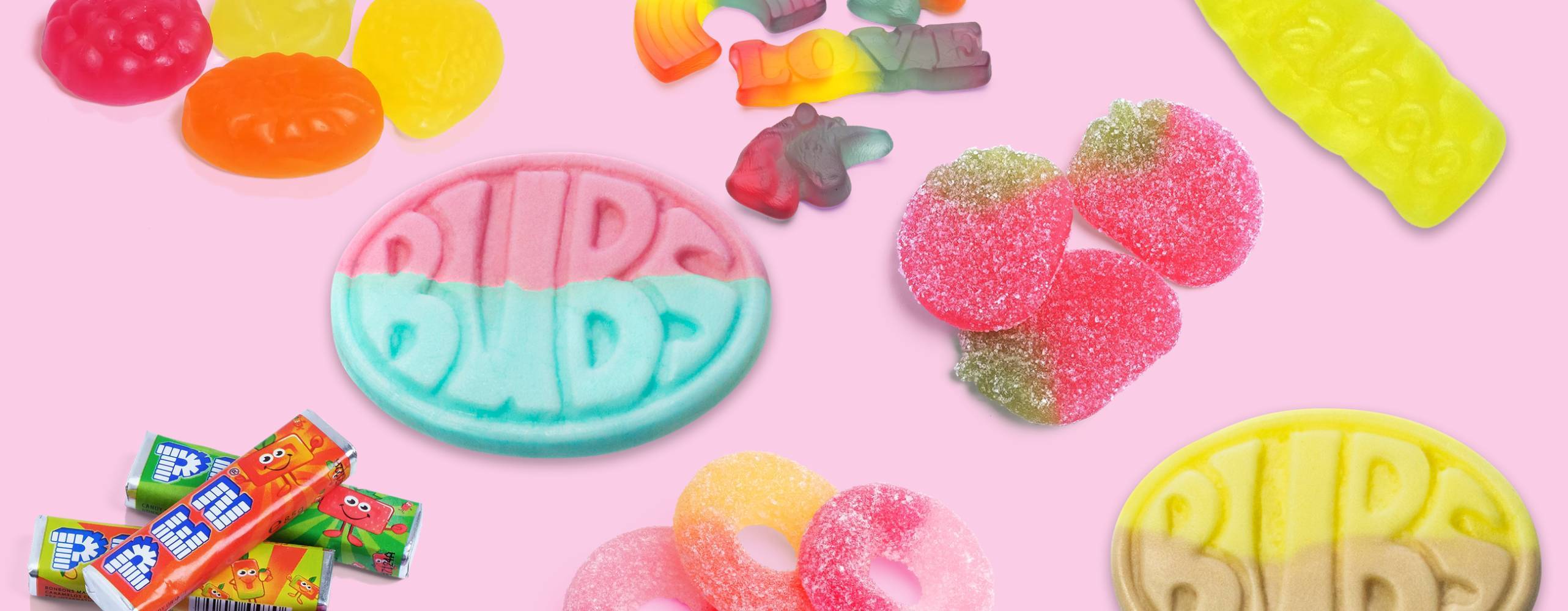 flera söta veganska godisar utspridda mot en ljusrosa bakgrund