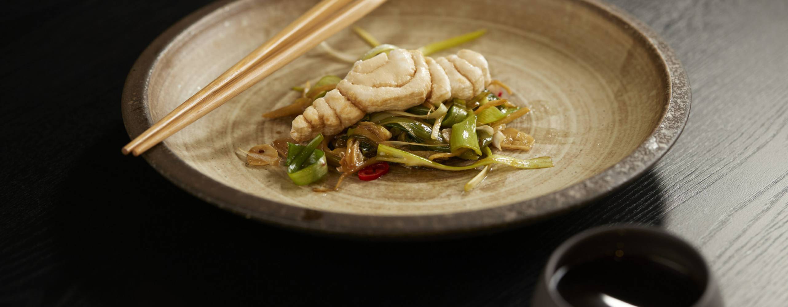 3D printad fiskfilé i en maträtt på en tallrik med ätpinnar på sida