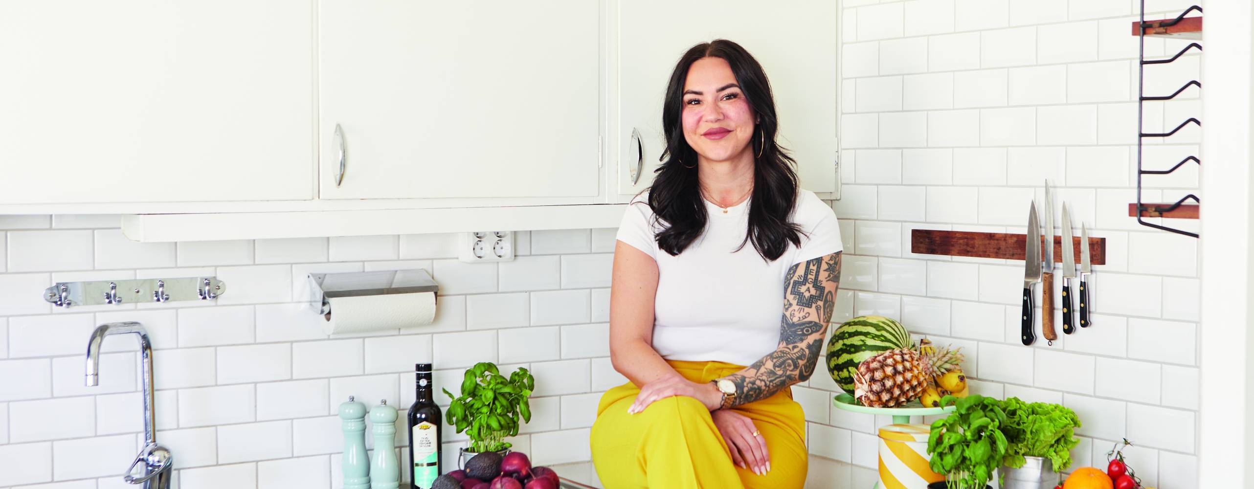 En kvinna som sitter på en köksbänk i ljusa färger