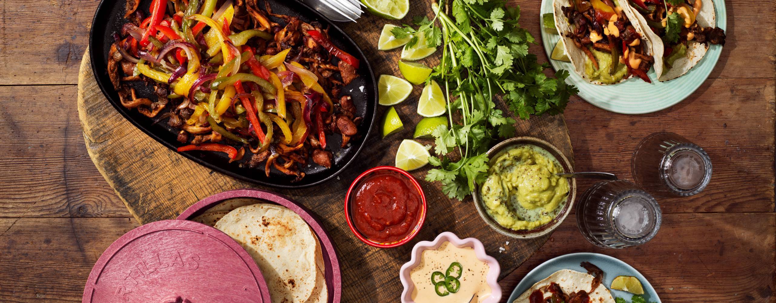 Tacotillbehör på ett träbord, bilden tagen uppifrån