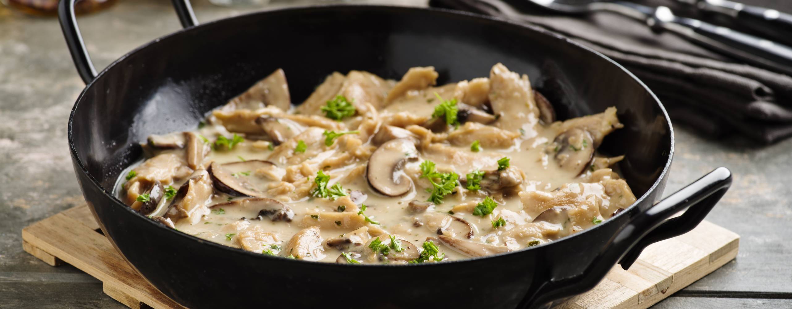 Vegan soy meat stripes and mushrooms in creamy sauce